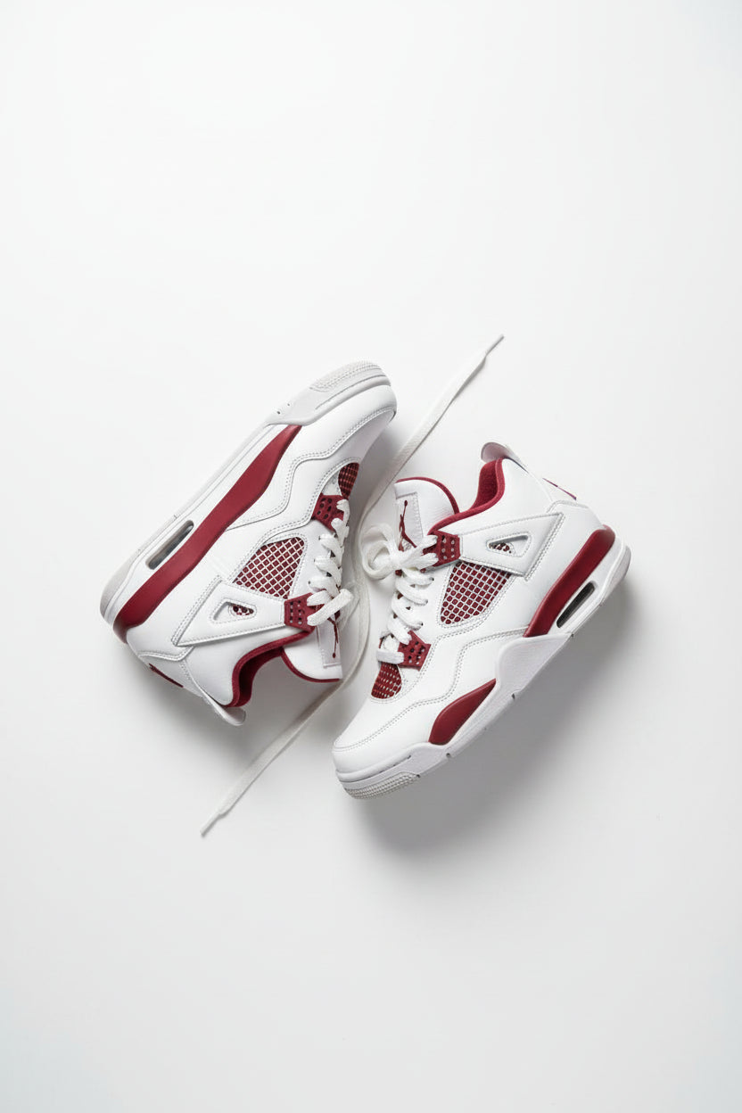 Pair of white and red sneakers on a dark green grass-like background