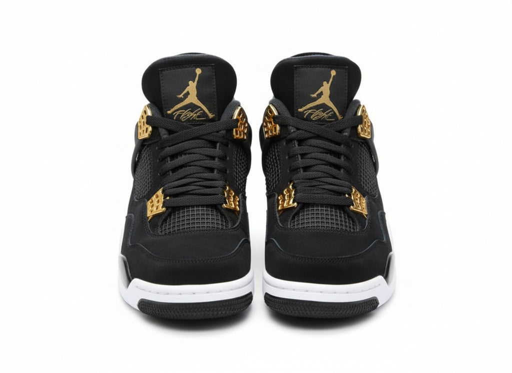 Black sneakers with gold accents on a textured gray surface